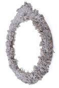 An oval bevelled edge wall mirror. With bead work wreath decoration.