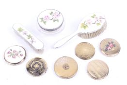 Six compacts and an enamelled dressing table set.