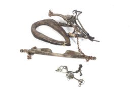 An assortment of vintage horse equipment. Including a collar and yoke, a harness, etc.
