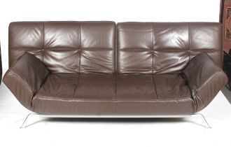 A Ligne Roset Smala three seater brown leather sofa bed. Raised on metal support.