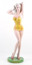 A contemporary 1950s style 'pin-up' bathing beauty plaster figure. On a green base.