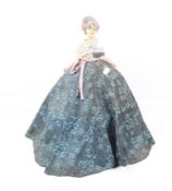 An early 20th century wax half doll in a crinoline style dress.