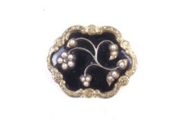 A Victorian gold, black enamel and half pearl shaped oval mourning brooch.