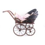 A reproduction Victorian convertable doll's pram and baby.