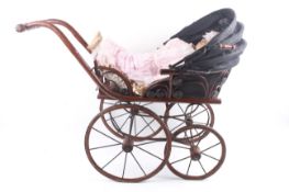 A reproduction Victorian convertable doll's pram and baby.