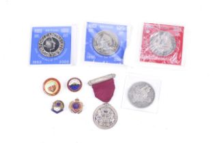 An assortment of 20th century coins and badges.