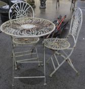 A vintage metal framed garden furniture set of a circular table and two chairs.