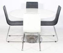 A contemporary white vinyl circular dining table and four matching chairs.
