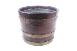 A 19th century coopered brass bound mahogany bucket. Of tapering form, with a zinc liner.