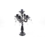 A black pressed glass lustre five-arm candelabra.