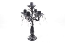 A black pressed glass lustre five-arm candelabra.