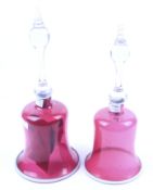 Two Victorian cranberry glass bells. With clear handles topped with finials, Max.