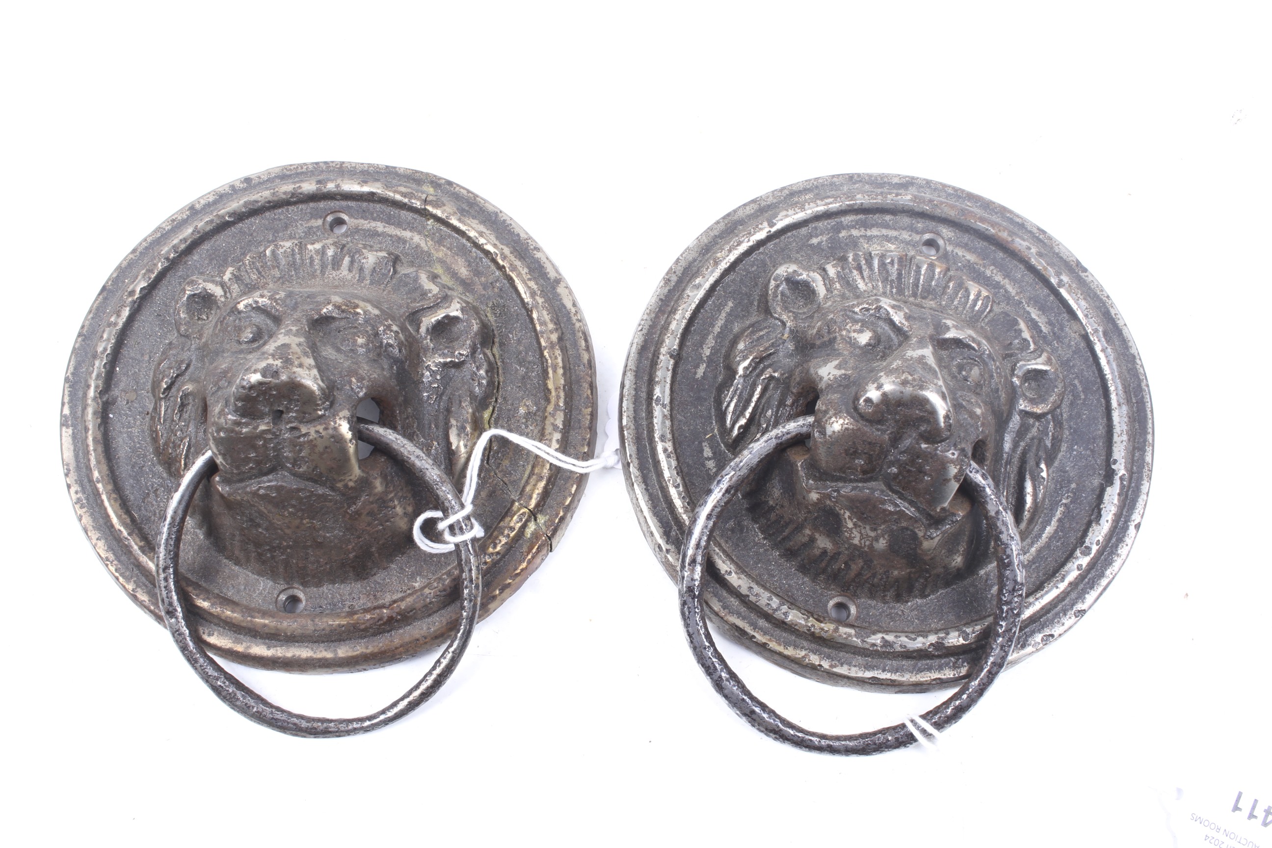 A pair of cast metal circular lion masks door pulls.