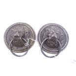 A pair of cast metal circular lion masks door pulls.