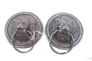 A pair of cast metal circular lion masks door pulls.