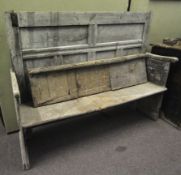 A rustic 19th century panel back settle bench.