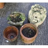 A reconstituted stone lion head and three terracotta pots.