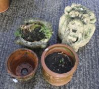 A reconstituted stone lion head and three terracotta pots.