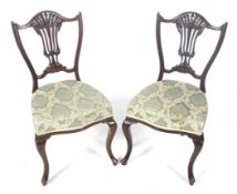 A pair of Edwardian carved mahogany shield back side chairs.