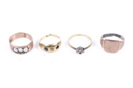 Four gold and gem set rings.