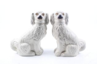 A pair of Staffordshire spaniels. Glazed in white with gilt details, H24.