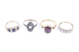 A group of four gem-set rings.