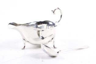 A silver sauce boat and a sauce ladle.