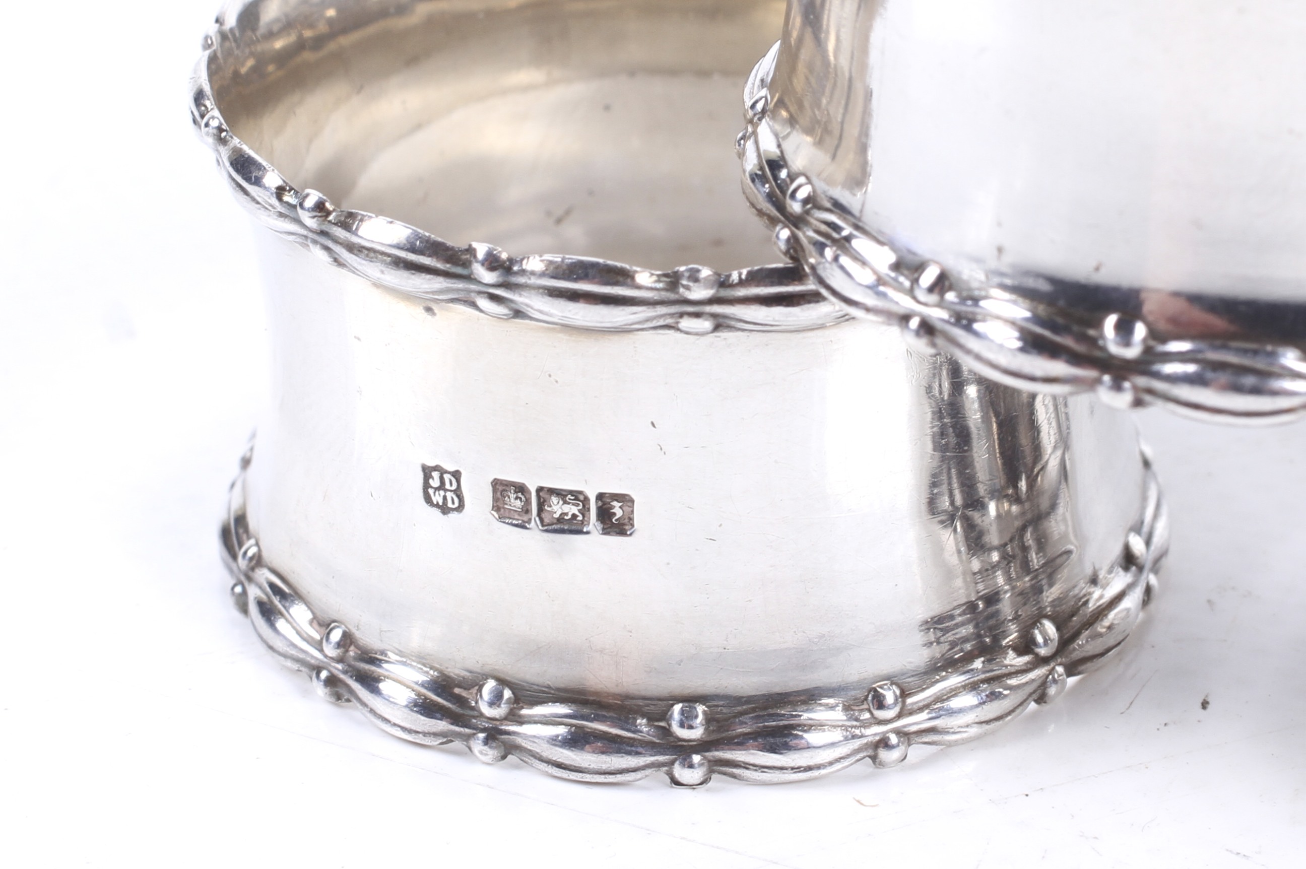 A set of four silver napkin rings and two others. - Image 2 of 2