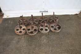 Two sets of four cast iron wheels. All complete with axles.