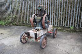 A Lister stationary engine. On metal chassis with wheels, complete with starting handle.