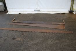 Three large iron saw blades. Including a two cross example with handles, max L230cm.