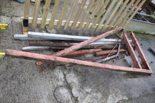 A group of vintage horse drawn cart shafts and metalwork.