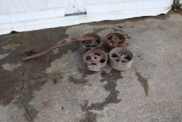Four cast iron stationary engine wheels. In various sizes, one with axle, largest Diameter 23cm.