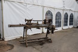 A vintage wood turning lathe. On a metal stand.