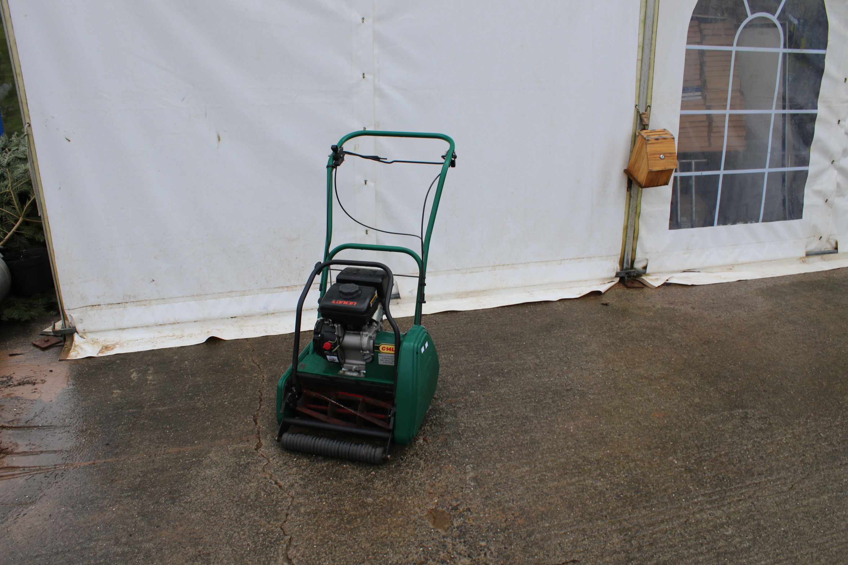 A Loncin petrol push along lawn mower. Complete with rear roller, in green.