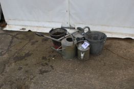 Three galvanised watering cans and two buckets.