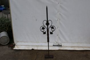 A large wrought iron spike finial on a stand.
