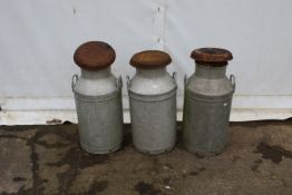 Three galvanised metal churns.