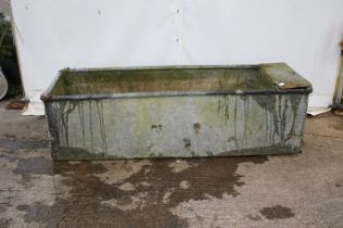 A galvanised riveted drinking trough. Complete with a plumbing box, H56cm x W186cm x D64cm.