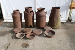 A collection of milk churns and churn lids.