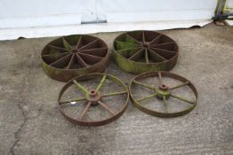 Two pairs of large cast iron wheels. Largest diameter, 62cm.