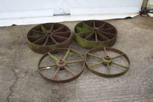 Two pairs of large cast iron wheels. Largest diameter, 62cm.