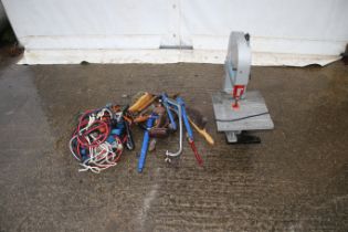 An electric bench saw and an assortment of tools. Noting jump leads, wrenches and brushes etc.