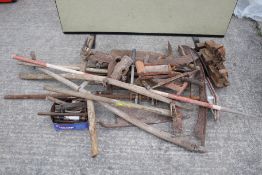 An assortment of vintage tools. Featuring scythes, hay knives plus two vices etc.