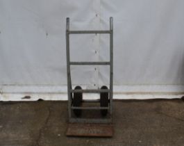 A heavy duty set of sack trucks. Painted silver, one tyre requires attention, H121cm.