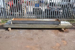 A galvanised metal feeder trough and a quanitity of corrigated motorway crash barriers