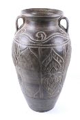 A 20th century large metal twin handled pot. Of tapering form with carved decoration, unmarked, H62.