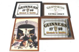Three Guinness advertising wall mirrors and a printed tin promotional picture.