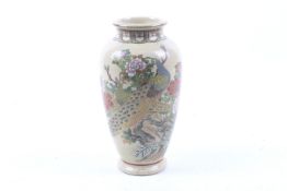 A Japanese Satsuma vase decorated with peacocks amongst peonies.