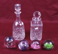 Two 20th century decanters and four paperweights.
